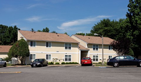 an apartment building with cars parked in a parking lot