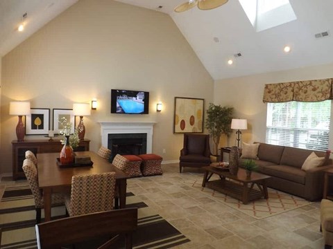 A living room with a fireplace and a television on the wall.