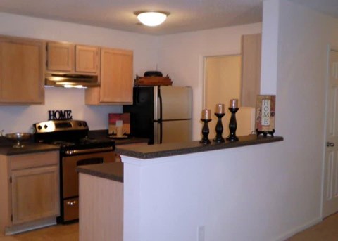 A kitchen with wooden cabinets and a black stove top oven.