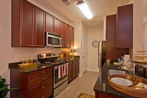 A kitchen with brown cabinets and a black counter top.