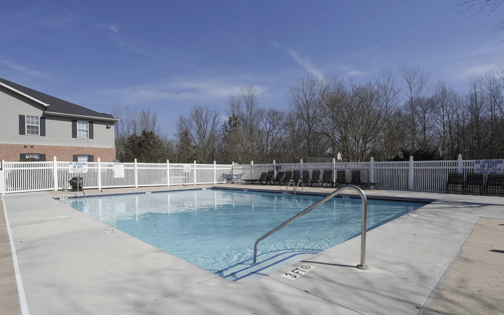 a swimming pool with a fence around it in front of a house