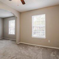 A room with a window and a fan on the ceiling.