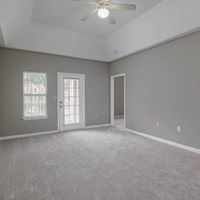 A room with a ceiling fan and two doors.