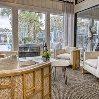 A room with a table and chairs in front of a window.