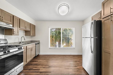 A kitchen with wooden cabinets and a white fridge.