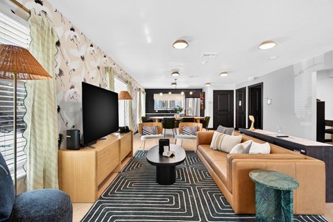 A modern living room with a large sofa, a coffee table, and a television.