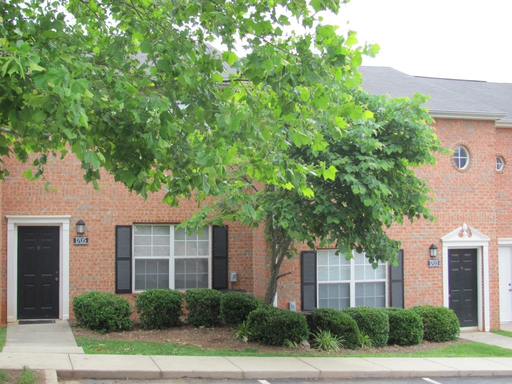 a building with trees and bushes in front of it