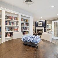 A living room with a fireplace and a bookshelf filled with books.