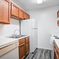 A kitchen with white appliances and wooden cabinets.