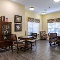 A room with a table and chairs and pictures on the wall.