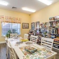 A room with a table and chairs and a puzzle on the table.
