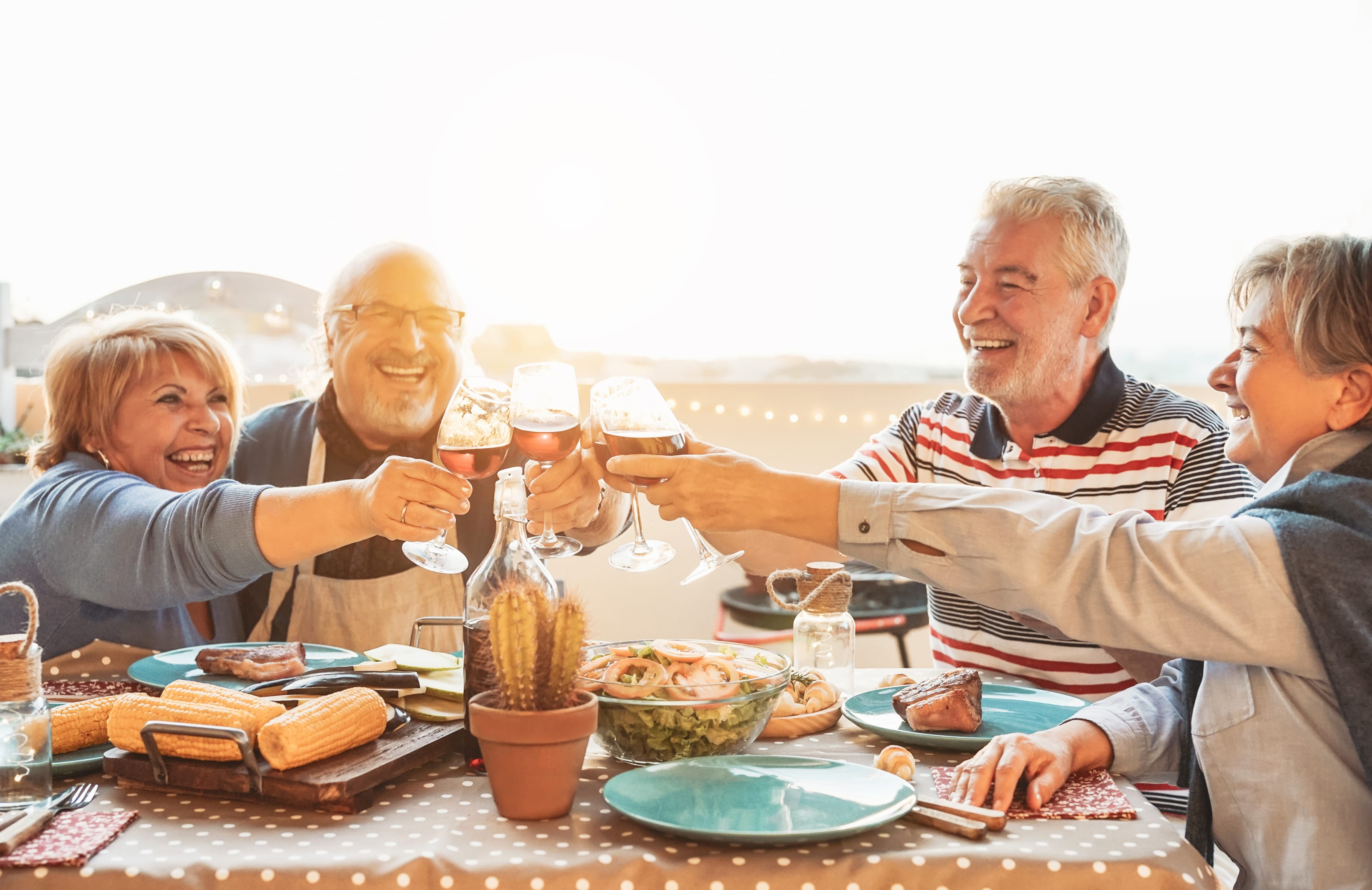 A group of people toasting with wine glasses at a dinner table.