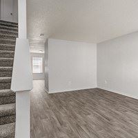 A room with a staircase and a white wall.
