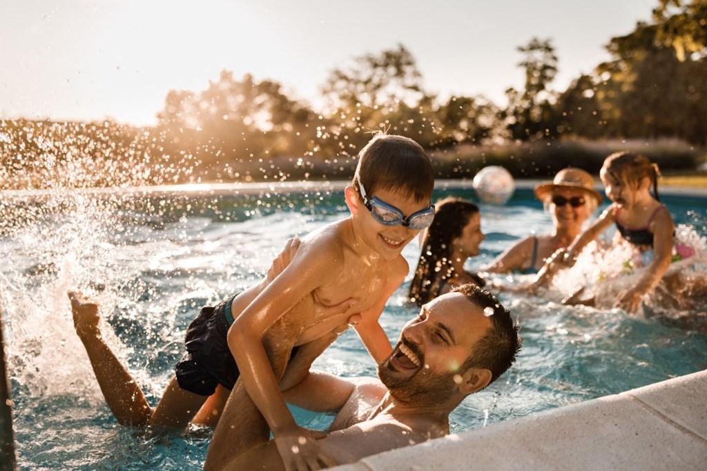 a family swimming in a pool with a child