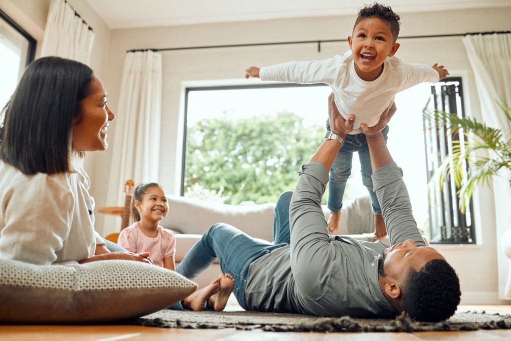 a family playing in their living room with a child on their
