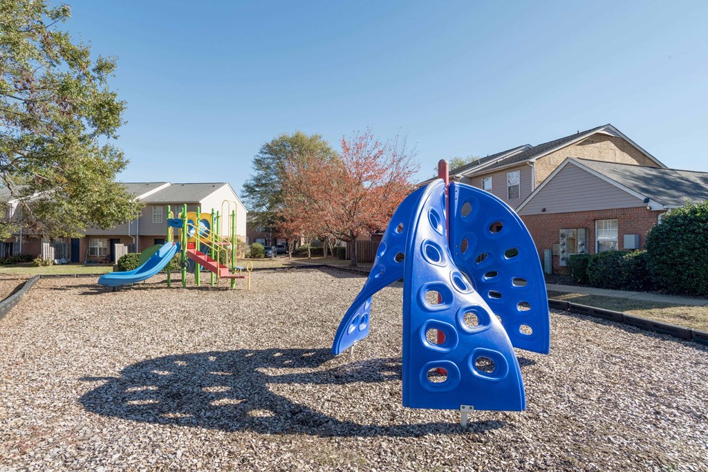 A playground with a blue slide and a blue climbing structure.