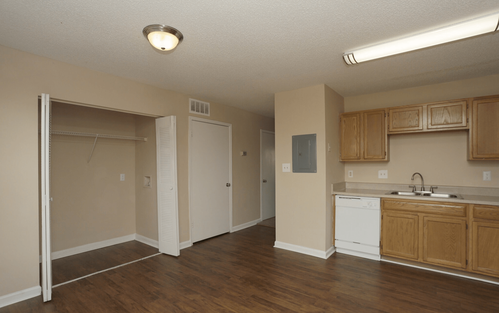 an empty kitchen and living room with a sink and a refrigerator