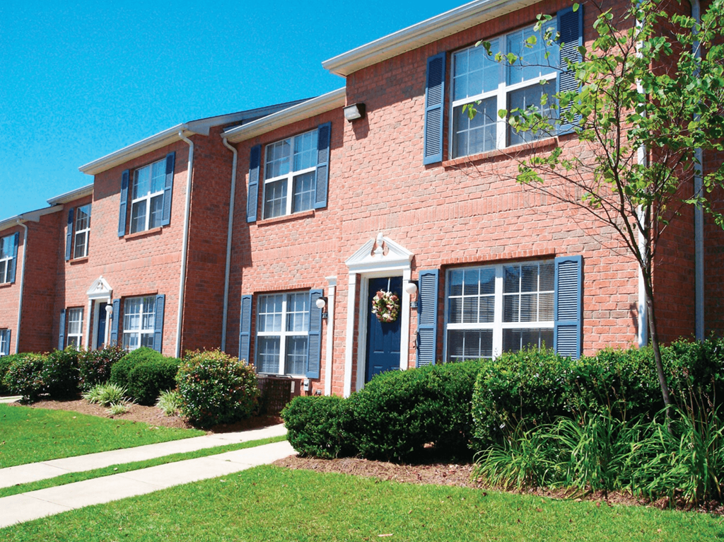 the front of a brick apartment building with a blue door at Jamestown Pointe Apartments, Greenville