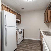 A white refrigerator is in a kitchen with wooden cabinets.