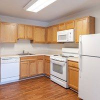 A kitchen with wooden cabinets and white appliances.