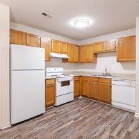 A kitchen with wooden cabinets and white appliances.