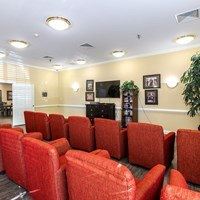 A room with red chairs and a television.