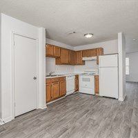 A kitchen with white appliances and wooden cabinets.