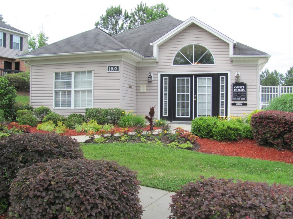 a home with a lawn and garden in front of it