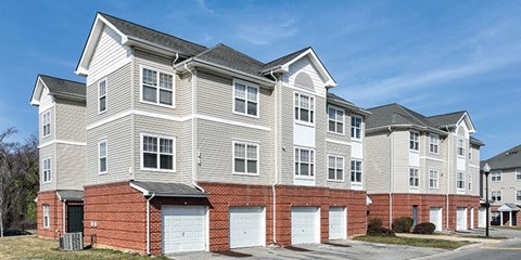 A large, multi-story residential building with a brick base and white upper floors.