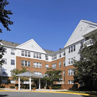 A large white and brown building with a covered walkway.