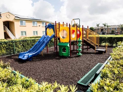 A playground with a blue slide and a yellow and red structure.