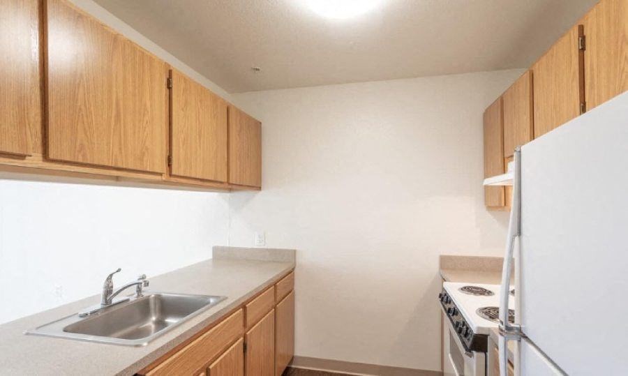 A kitchen with wooden cabinets and a white refrigerator.
