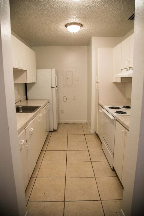 A kitchen with white appliances and cabinets.