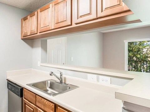 A kitchen with a white counter top and brown cabinets.