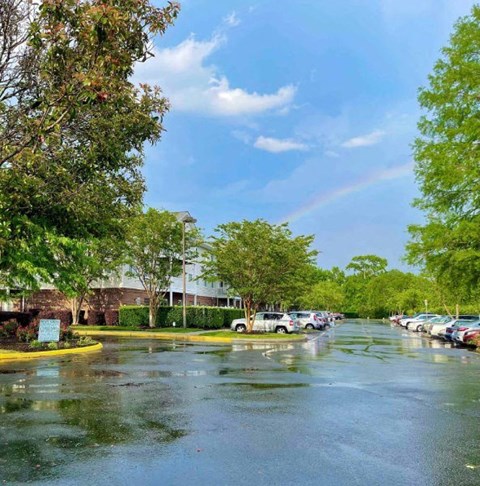 a rainy street with cars parked in a parking lot at Greenbrier Seniors Apartments, Chesapeake, VA 23320