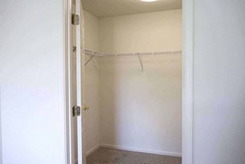 A white closet with a door and a hanger rod.