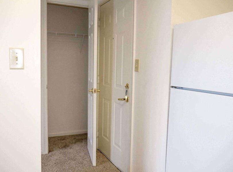 a white door in a room with a refrigerator at Greenbrier Seniors Apartments, Chesapeake 