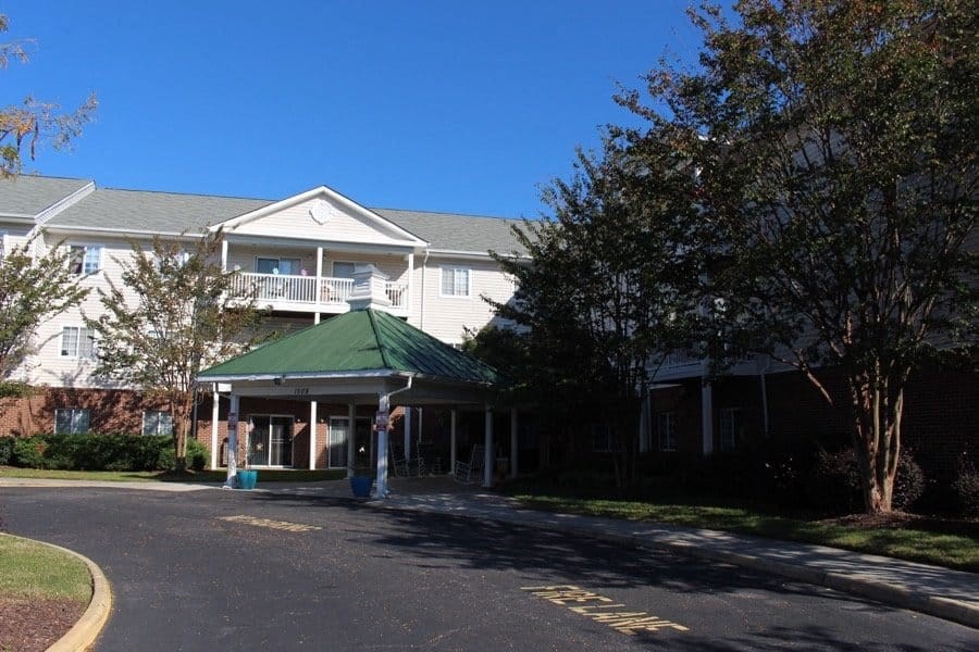 a building with a green roof on the side of a street at Greenbrier Seniors Apartments, Virginia  