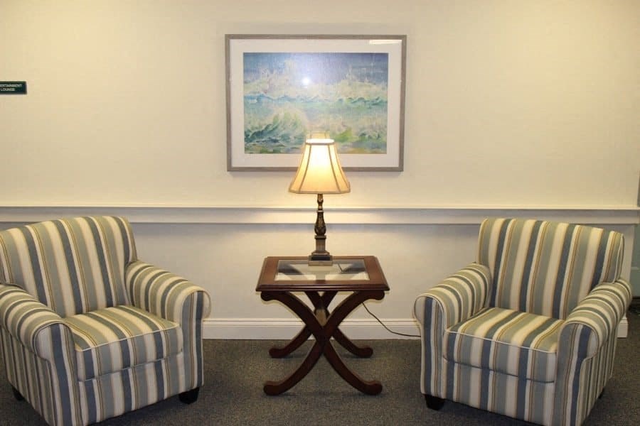 a living room with two chairs and a table with a lamp at Greenbrier Seniors Apartments, Chesapeake, 23320  