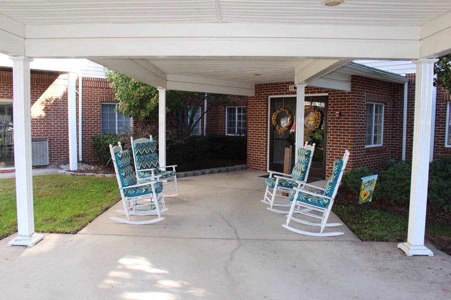 a group of rocking chairs sitting on a porch at Greenbrier Seniors Apartments, Chesapeake, Virginia  