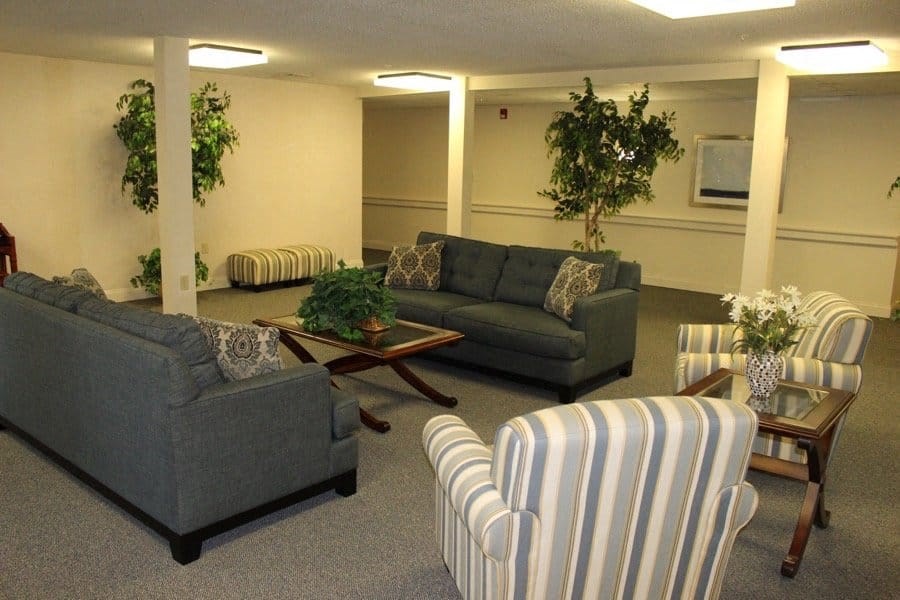 a living room with couches and chairs and a table at Greenbrier Seniors Apartments, Chesapeake 