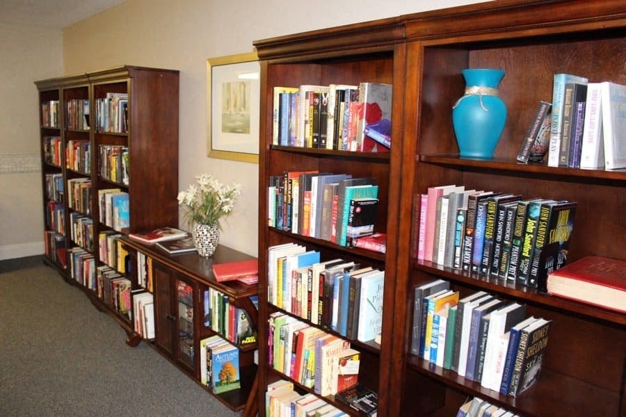 a book shelf filled with lots of books at Greenbrier Seniors Apartments, Chesapeake, VA 23320  