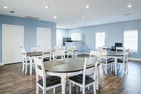 A dining room with a round table and chairs.