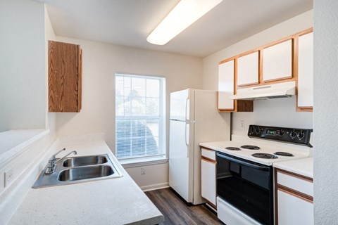 A kitchen with a black oven and white countertops.