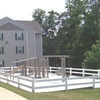 A white fence surrounds a playground.