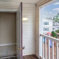 A white door with a brown frame is open to a balcony.