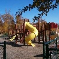 A yellow slide in a playground.
