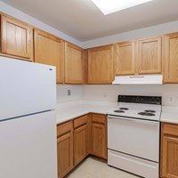 A kitchen with wooden cabinets and white appliances.