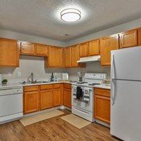 A kitchen with wooden cabinets and white appliances.