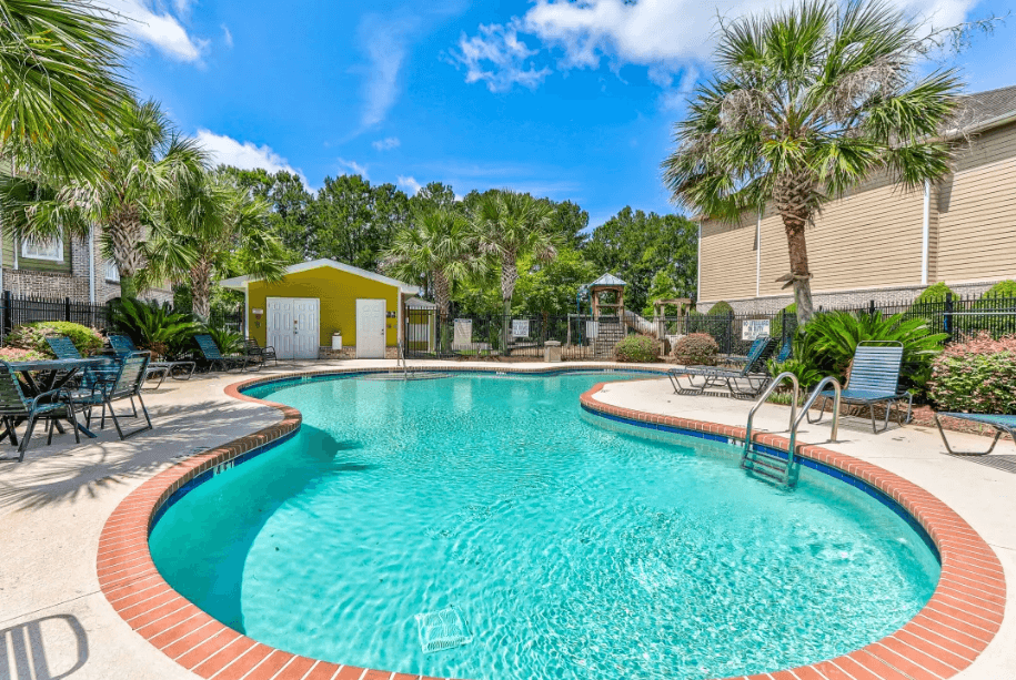 a swimming pool with chairs and palm trees